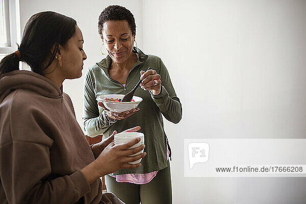 Mother and daughter eating fruit and drinking coffee