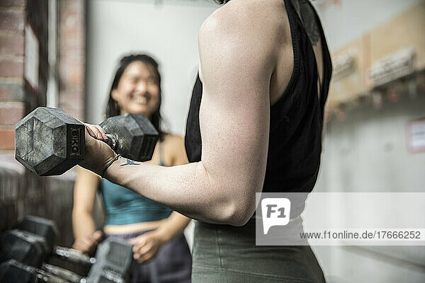 Close up woman working out with dumbbell in gym