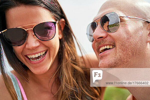 Close up happy couple in sunglasses laughing