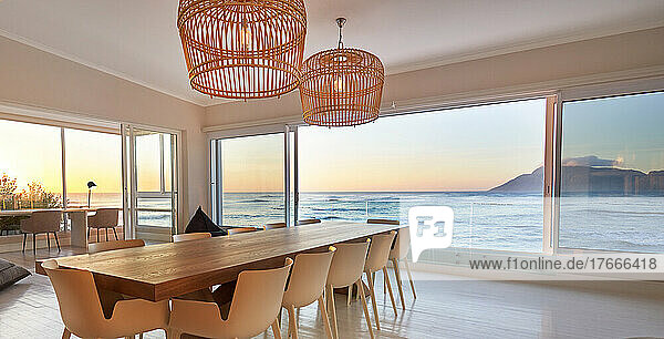Rattan pendant lights over dining table with scenic ocean view