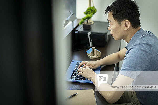 Male architect working at laptop in office