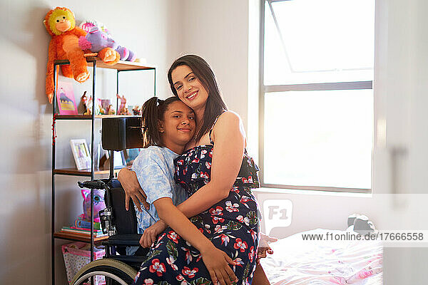 Portrait happy  affectionate mother hugging disabled daughter at home