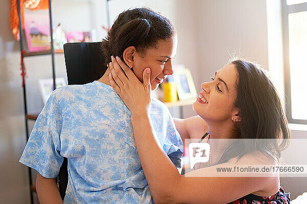 Happy mother and disabled daughter face to face