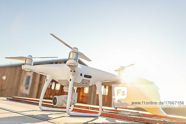 Drohnen-Quadcopter neben Schutzhelm auf einer Baustelle