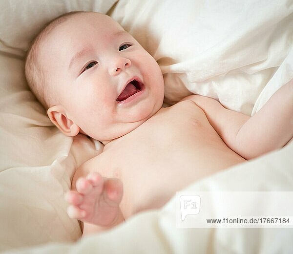 Young mixed-race chinese and caucasian baby boy having fun on his blanket