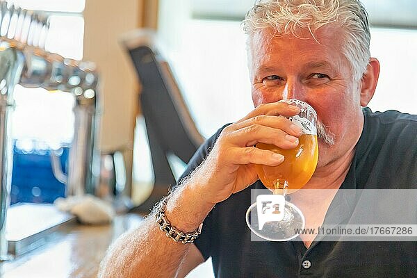 gutaussehender Mann bei der Verkostung eines Glases Mikrobrau-Bier