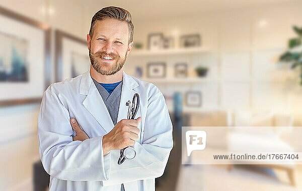 Hübscher junger erwachsener Arzt mit Bart im Büro