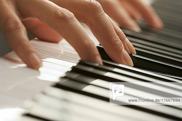 Die Finger einer Frau auf den Tasten eines Digitalpianos
