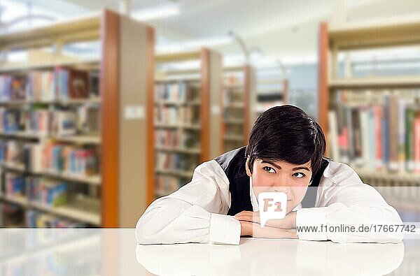 Junge gemischtrassige Studentin träumt in der Bibliothek und schaut nach links