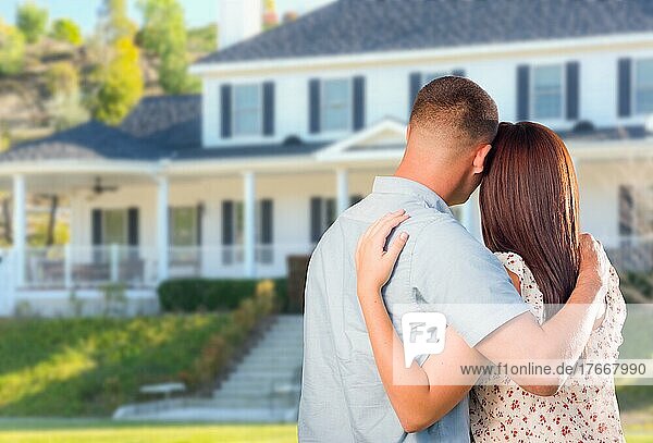 Affectionate military couple looking at beautiful new house