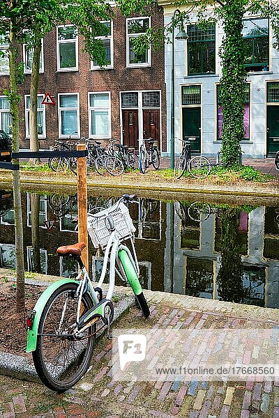 Netherlands popular means of transport bicycle parked near the canal in Delft street with old houses  Delft  Netherlands