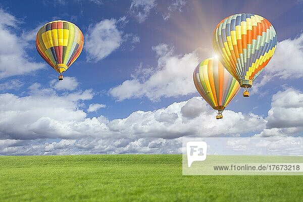 Zwei Heißluftballons in den schönen blauen Himmel mit Grasfeld unten