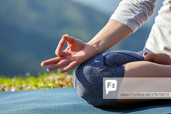 Nahaufnahme von Frau in Padmasana Yoga Lotus-Pose mit Kinn Mudra im Freien mit copyspace