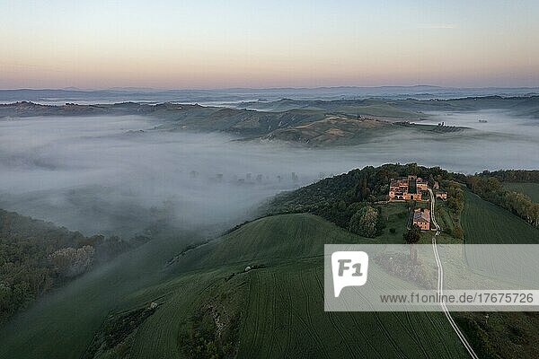 Luftaufnahme  Hügelige Landschaft mit Nebel  typisches Landhaus  Sonnenaufgang  Crete Senesi  Provinz Siena  Toskana  Italien  Europa