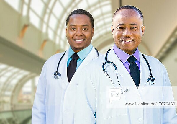 Two handsome african american male doctors inside hospital office