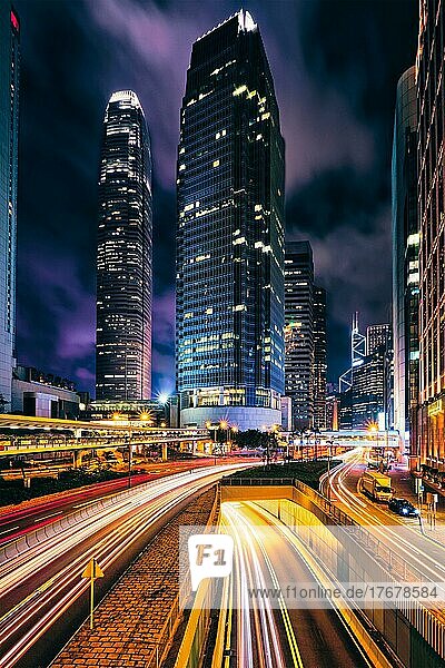 Street traffic in Hong Kong at night. Office skyscraper buildings and busy traffic on highway road with blurred cars light trails. Hong Kong  China  Asia