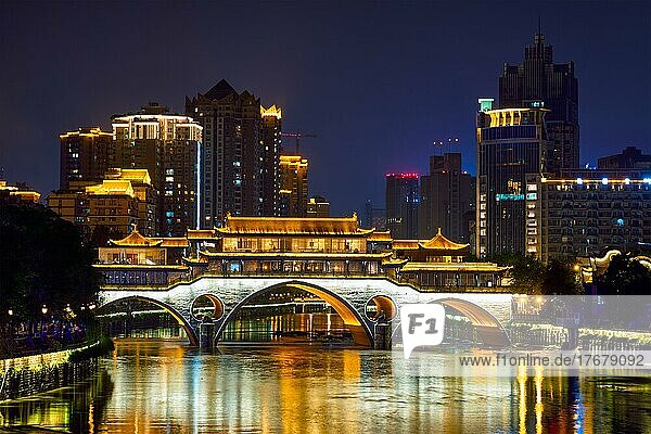 Famous landmark of Chengdu  Anshun bridge over Jin River illuminated at night with modern skyscrapers in background  Chengdu  Sichuan  China  Asia
