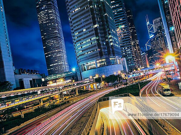 Straßenverkehr in der Nacht. Büro-Wolkenkratzer Gebäude und reger Verkehr auf der Autobahn Straße mit unscharfen Autos Lichtspuren. Hongkong  China  Asien