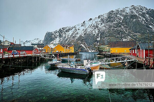 Pier mit Booten im Nusfjord Authentisches Fischerdorf im Winter mit roten Rorbu-Häusern. Lofoten Inseln  Norwegen  Europa