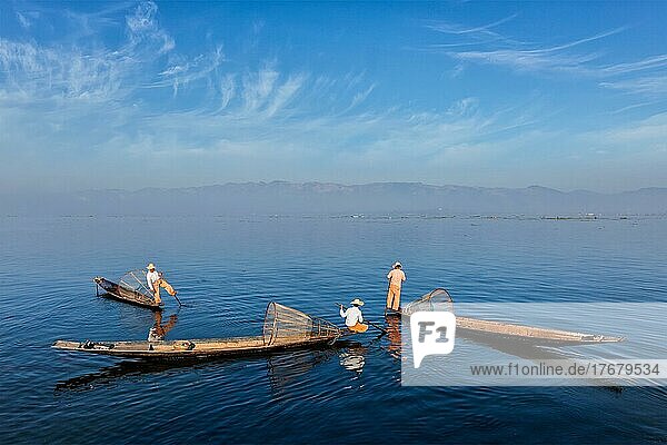 Traditionelle burmesische Fischer mit Fischernetzen auf Booten am Inle-See in Myanmar  der für seinen unverwechselbaren einbeinigen Ruderstil berühmt ist  sind das Wahrzeichen von Myanmar