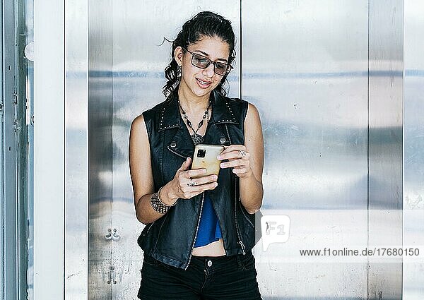 Attraktives Mädchen  das ihr Handy an der Aufzugstür benutzt  Eine Person  die im Aufzug SMS schreibt  Nahaufnahme eines städtischen Mädchens  das ihr Handy überprüft