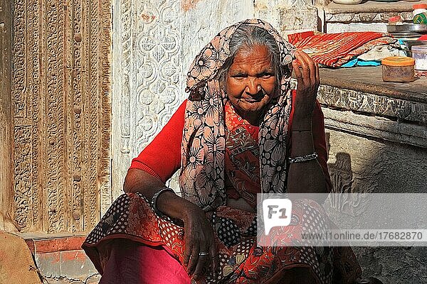 Ältere Frau in bunter Kleidung sitzt im Innenhof ihres Hauses  Rajasthan  Nordindien  Indien  Asien