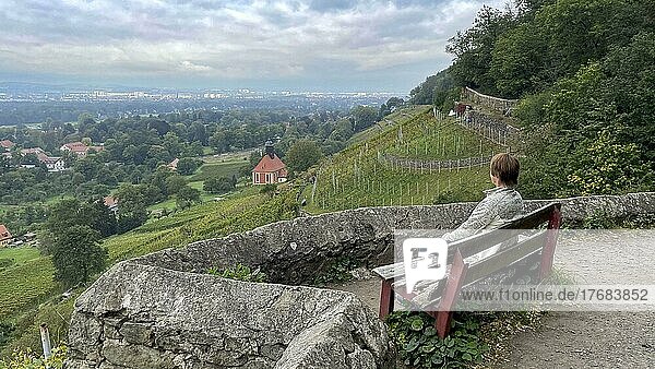 Young woman on a bench with view of the vineyard church and the vineyards near Pillnitz  Hosterwitz  Dresden  Saxony  Germany  Europe