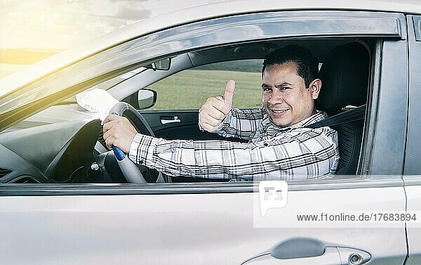 Porträt eines Mannes  der beim Fahren die Daumen nach oben zeigt  Mann im Auto  der die Daumen nach oben zeigt  glücklicher Mann im Auto