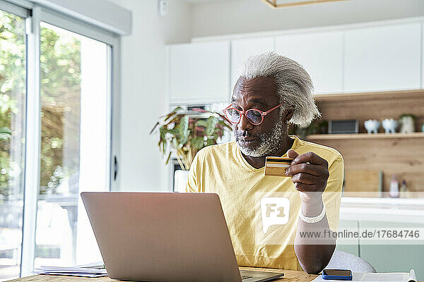 Senior man using laptop and credit card