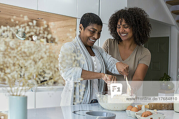 Mature woman and daughter-in-law preparing cookies