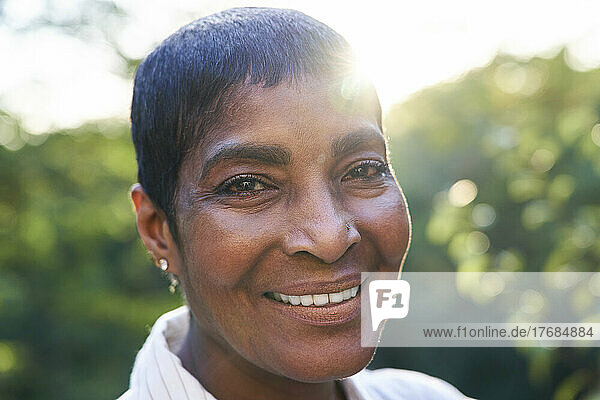 Close-up of a smiling senior woman standing in garden