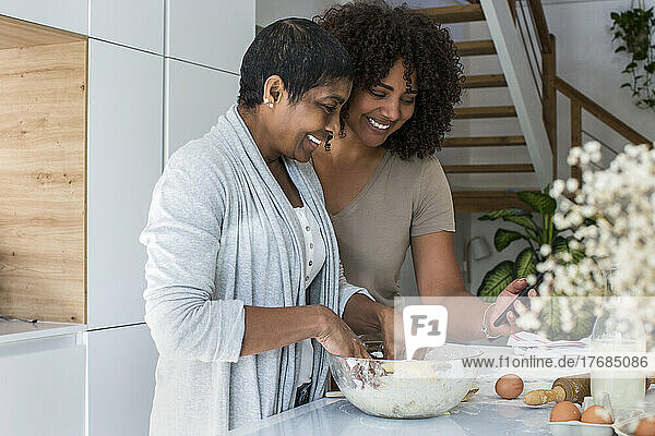 Mature woman and daughter-in-law preparing cookies