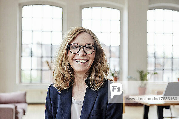 Happy businesswoman wearing eyeglasses at home
