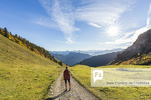 Germany  Bavaria  Female hiker standing in middle of road to Geigelstein mountain