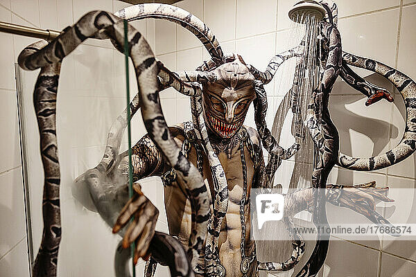 Man taking shower in spooky Medusa costume