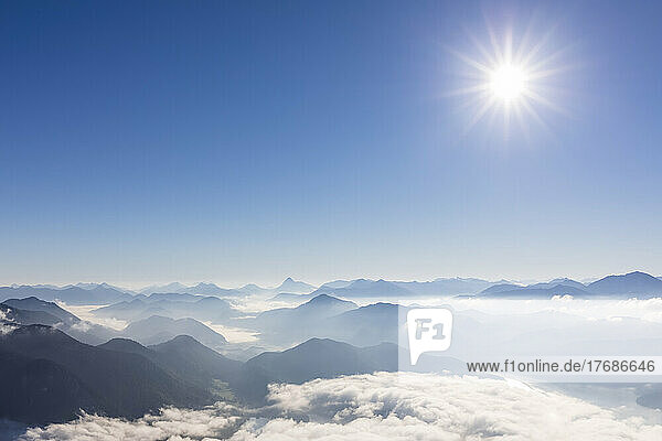 Germany  Bavaria  Summer sun shining over peaks of Bavarian Prealps shrouded in thick fog