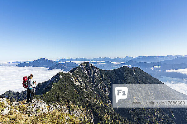Germany  Bavaria  Female hiker admiring view from mountaintop in Bavarian Prealps