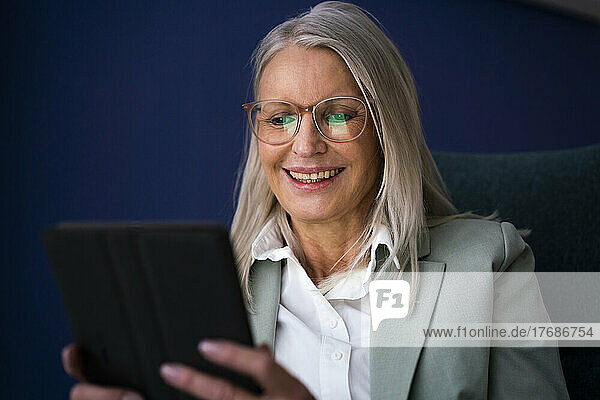 Lächelnde ältere Geschäftsfrau  die einen Tablet-PC verwendet