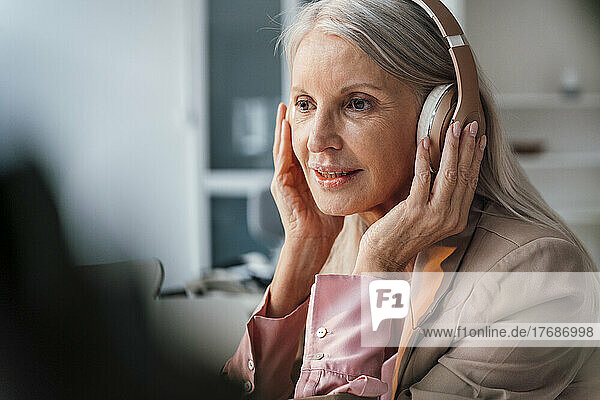 Businesswoman holding headphones at office