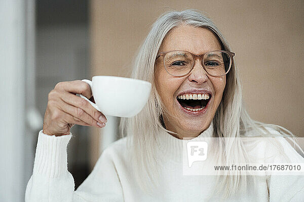 Cheerful senior woman holding coffee cup