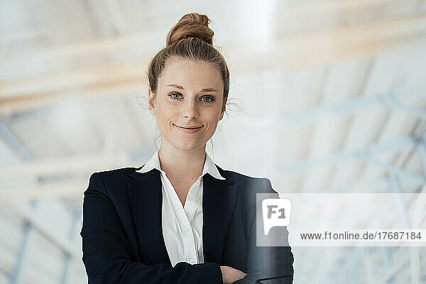 Confident businesswoman with hair bun at factory