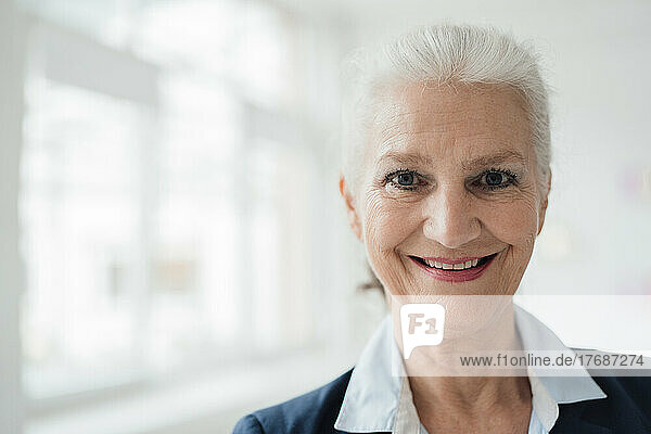 Happy senior businesswoman with gray hair in office