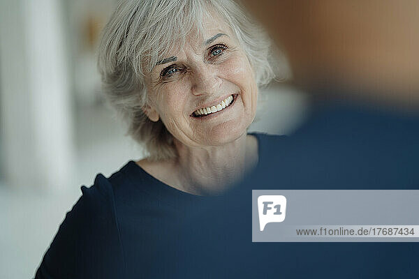 Happy businesswoman with gray hair in office
