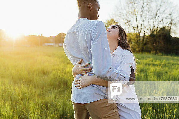 Young woman hugging boyfriend in nature