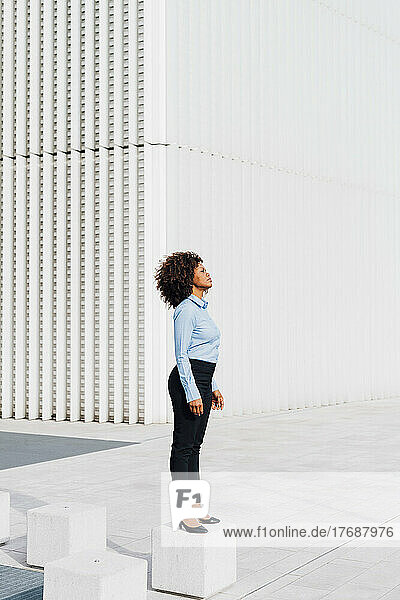 Afro businesswoman standing on concrete block