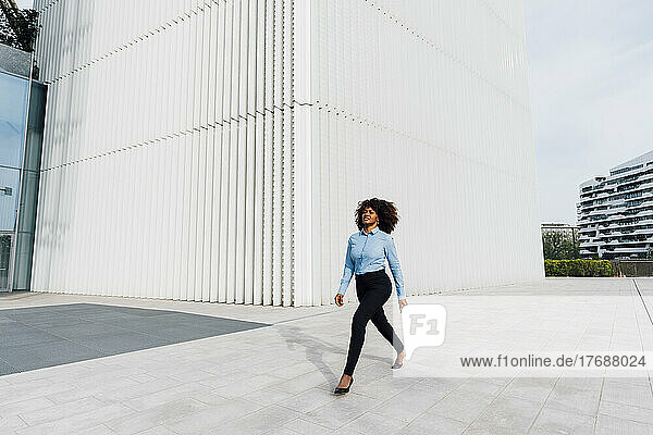 Afro businesswoman walking on footpath