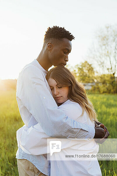 Young couple hugging each other in nature on sunny day