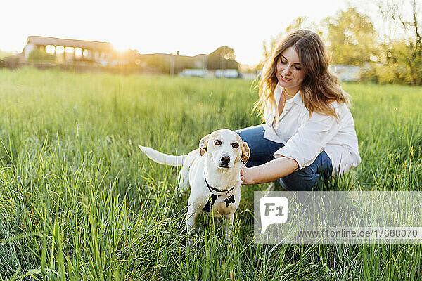 Smiling young woman with dog in nature