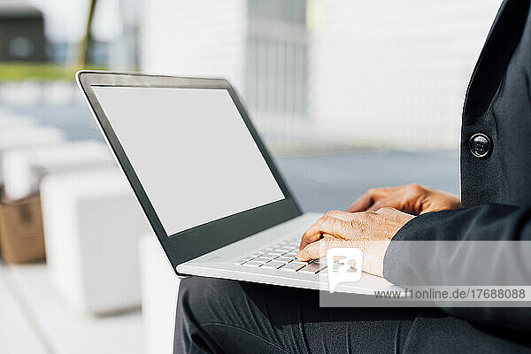 Hands of businesswoman typing on laptop