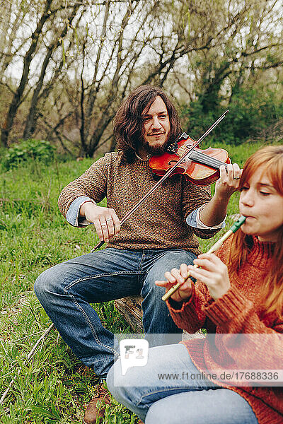 Mann und Frau proben mit Musikinstrumenten im Feld